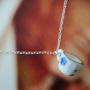 tiny tea cup necklace hanging on a silver chain