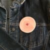 big red button brooch with red stitching details