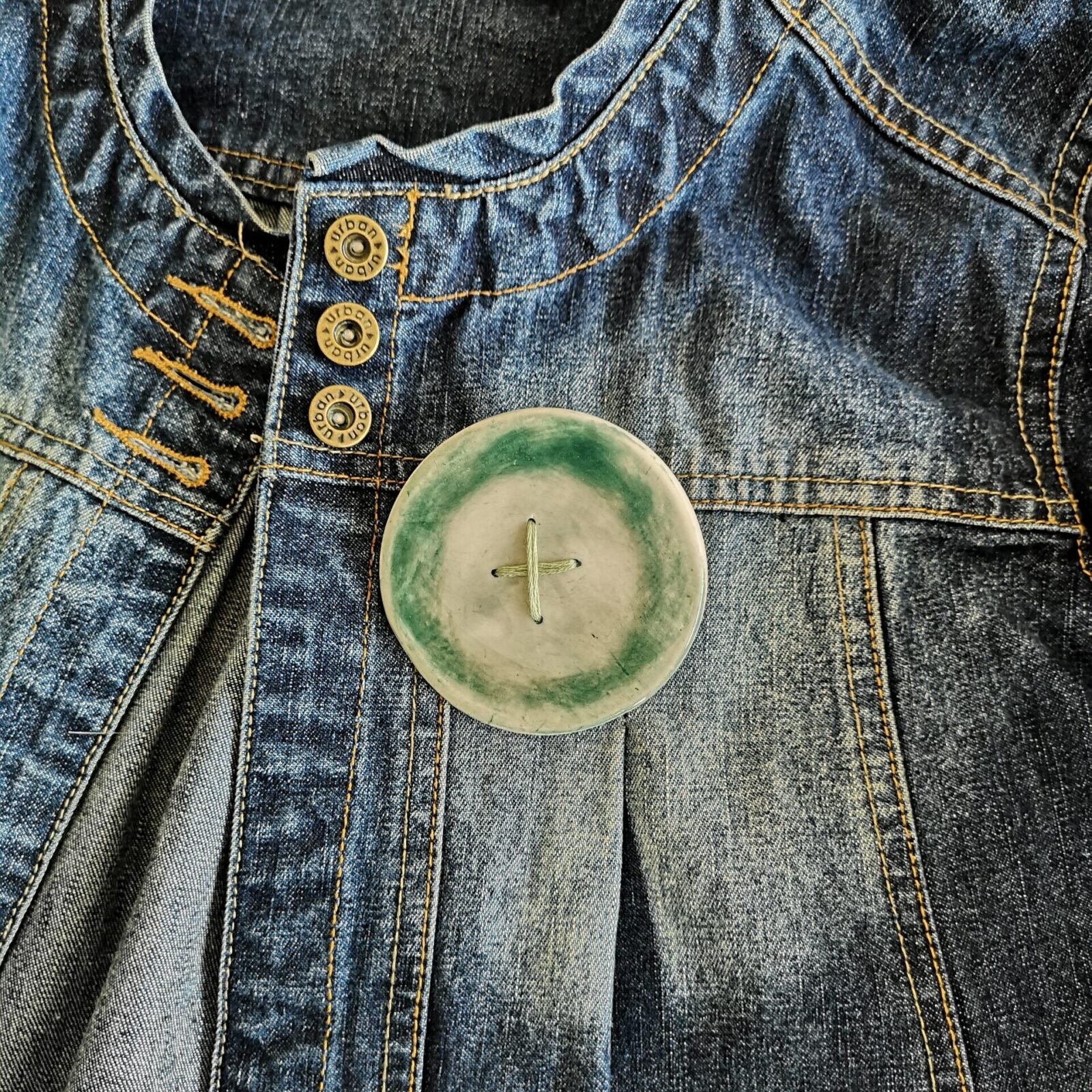 Big green button brooch with green stitching