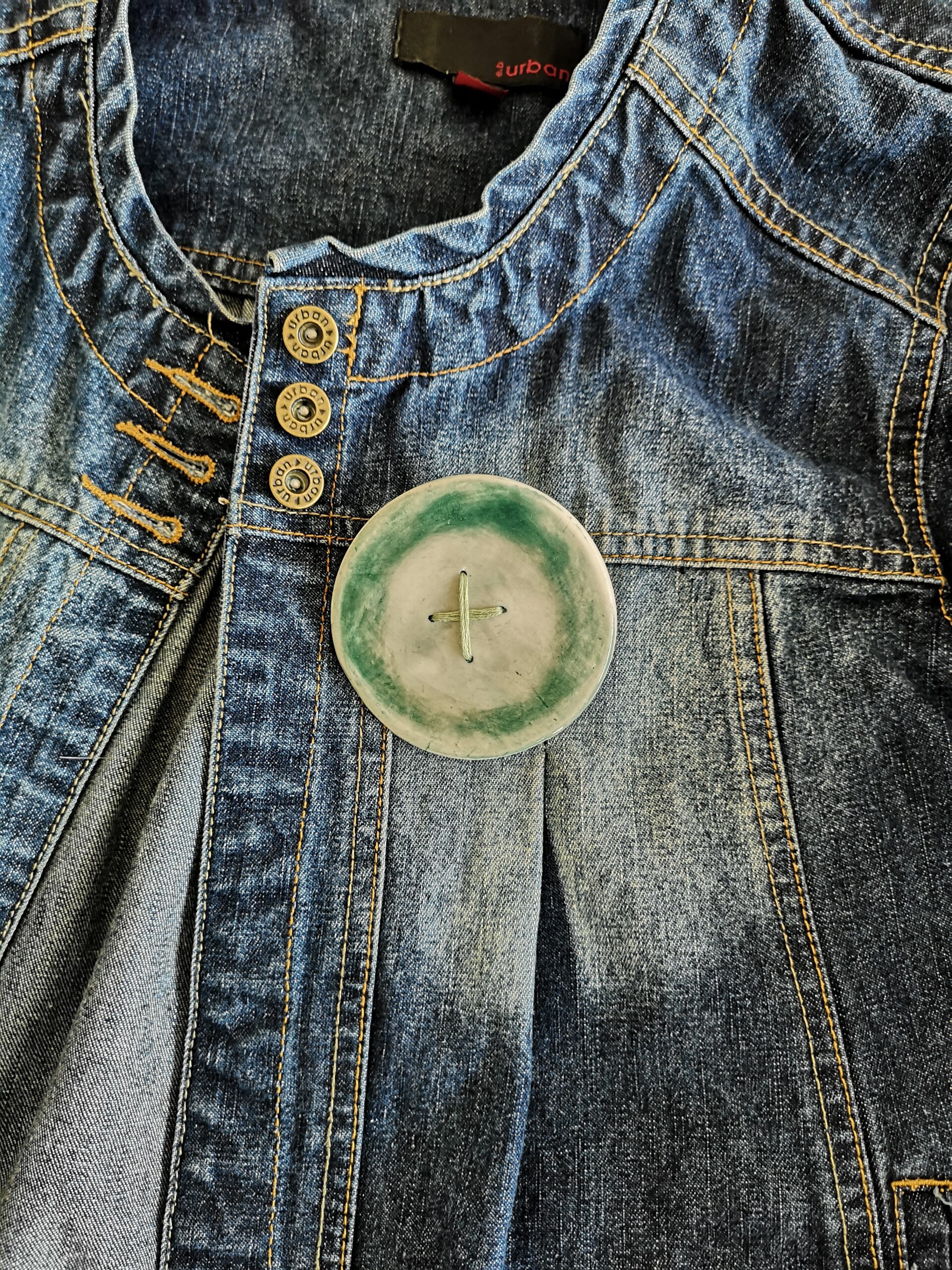 Big green button brooch with green stitching