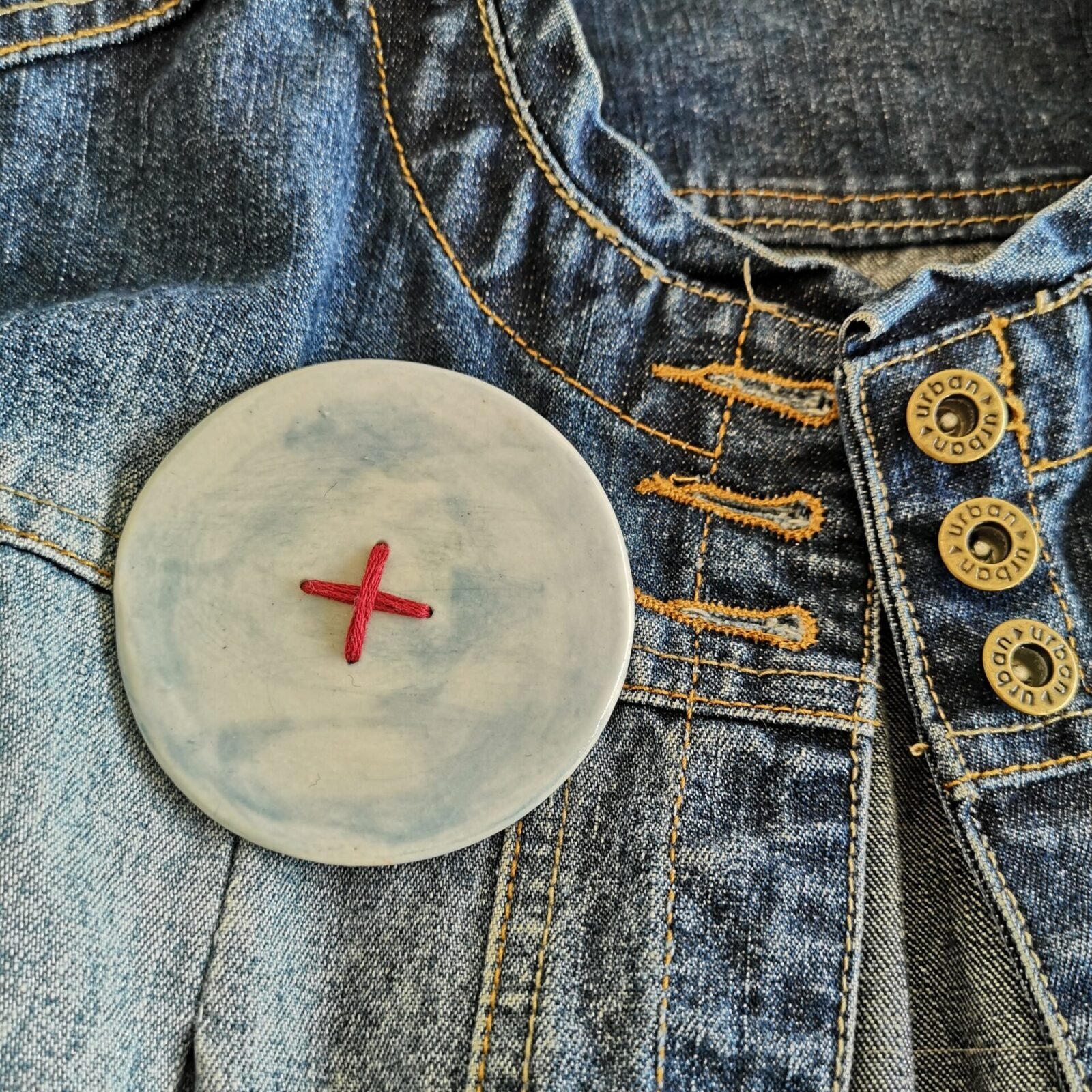 Big button brooch inn blue with red stitching