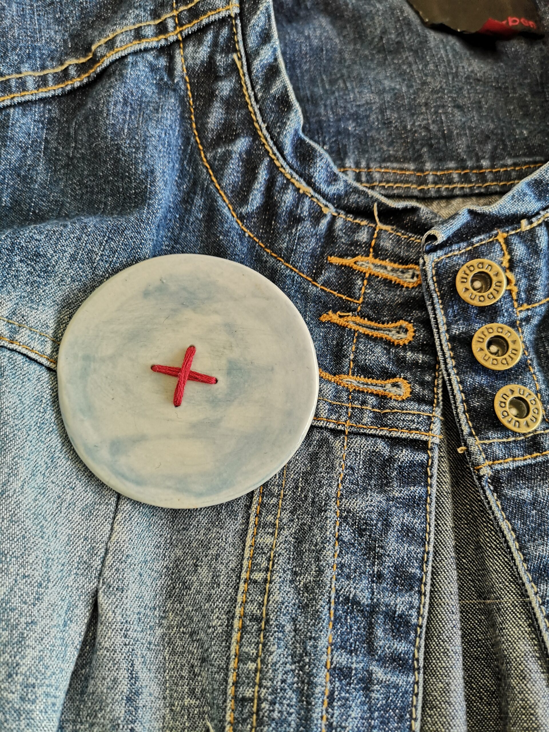 Big button brooch inn blue with red stitching